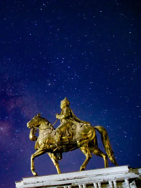 The golden horse statue under a starry sky